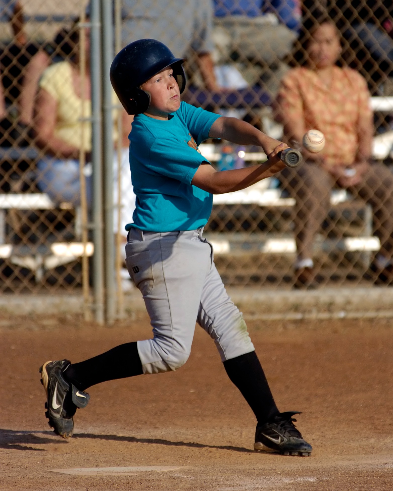 Youth baseball batter driving the ball during a swing