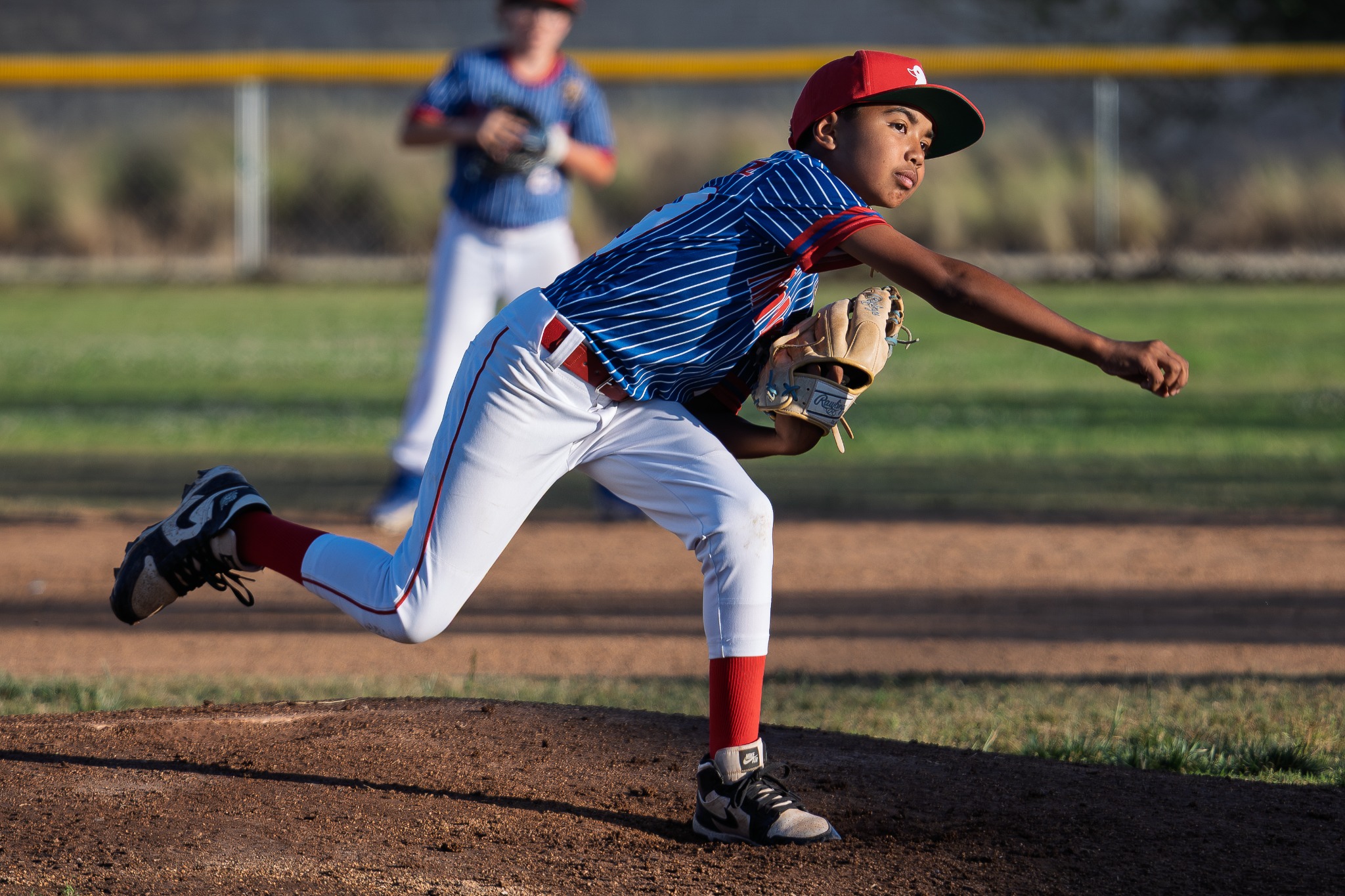 Baseball pitcher delivering the ball from the mound