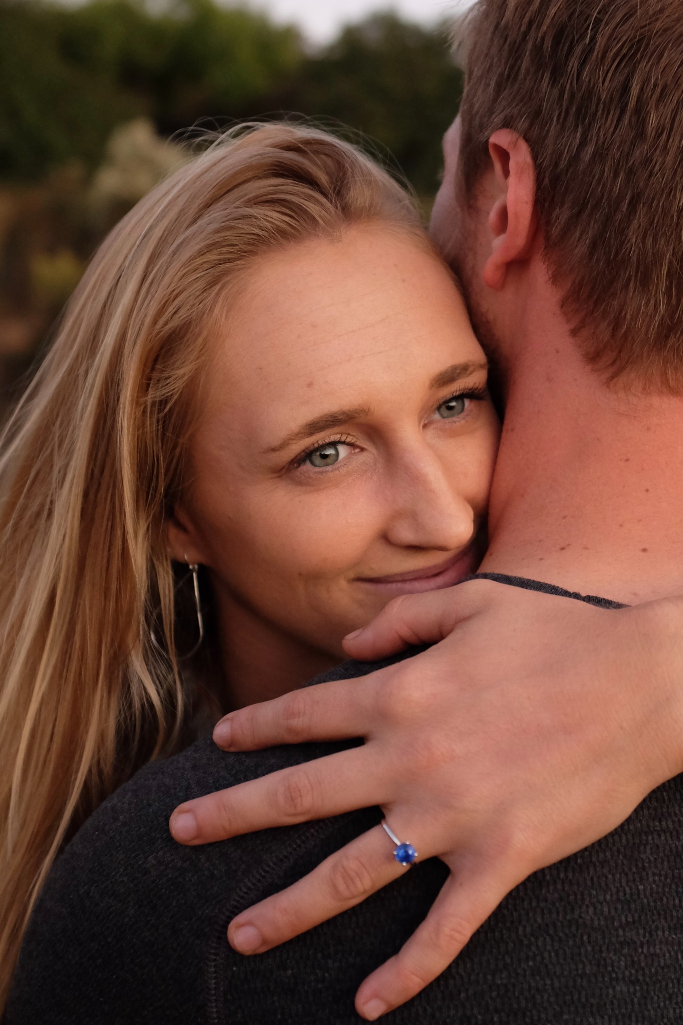 Close portrait of a woman embracing a man outdoors